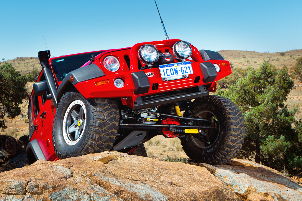 Bright red Jeep JK with lift kit, snorkel and accessories